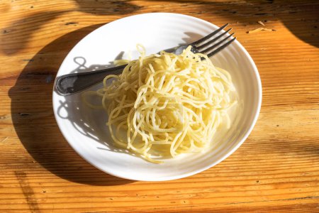 plate of Italian pasta on a wooden table illuminated by the sun. national dishes