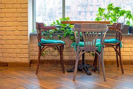 mesa con sillas y flores frescas cerca de la ventana. interior moderno