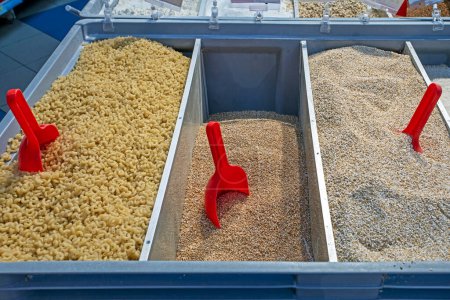 cereales a granel y pasta, pasta, trigo sarraceno, harina de avena en recipientes en peso en el supermercado. Ahorro presupuestario