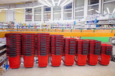 red carts for groceries and other goods are stacked in a supermarket