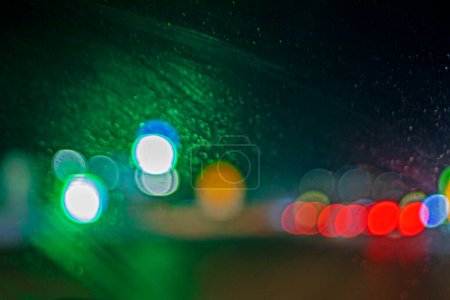 abstract blurred background of multi-colored car lights through the windshield, in the dark