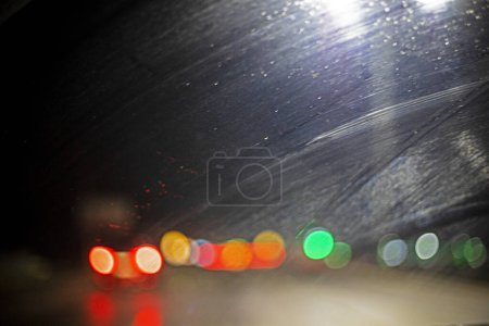 abstract blurred background of multi-colored car lights through the windshield, in the dark