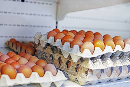 farm brown chicken eggs in cardboard containers on the store counter. Approaching Easter. Crisis and rising prices
