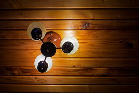 an der Wand montierter natürlicher Lampenschirm aus Glas auf Holzverkleidung. Öko-Design und Komfort zu Hause