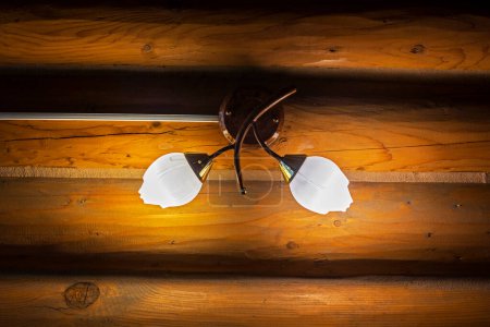 an der Wand montierter natürlicher Lampenschirm aus Glas auf Holzverkleidung. Öko-Design und Komfort zu Hause