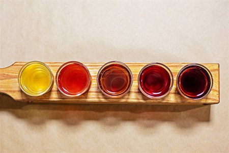 degustación de coloridos licores de frutas y bayas sobre un fondo artesanal. Fabricación de tinturas y licores caseros