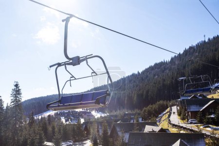 Leerer Skilift in einem Skigebiet am frühen Morgen von der Sonne beleuchtet. Aktive Familienfreizeit