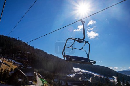 Skilift in einem Skigebiet am frühen Morgen von der Sonne beleuchtet. Aktive Familienfreizeit
