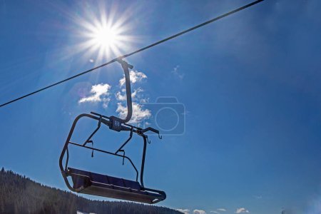 Skilift in einem Skigebiet am frühen Morgen von der Sonne beleuchtet. Aktive Familienfreizeit