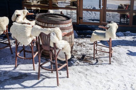 eco café al aire libre en invierno con pieles de oveja en una estación de esquí en un día soleado