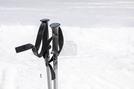 Skistöcke auf einem flachen, schneebedeckten Hang an einem sonnigen Tag. Aktive Erholung