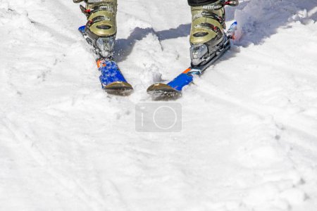 Skischuhe mit Skiern auf einem verschneiten Hang. Aktive Freizeit
