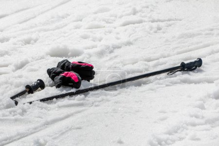 Skier mit Handschuhen auf nassem, losem Schnee am Hang an einem sonnigen Tag. Freizeit