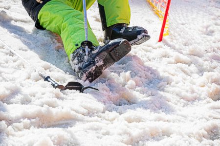 skieur met des chaussures de ski sur une pente enneigée. vacances actives en famille