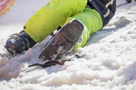 esquiador se pone botas de esquí en una pista nevada. vacaciones activas con la familia