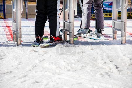 Téléchargez les photos : Skieurs entrant dans le téléski le matin. Vacances actives en famille - en image libre de droit