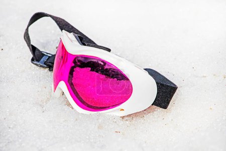 masque couché rose se trouve sur une pente enneigée humide par une journée ensoleillée. Hiver saison des neiges. Vacances actives en famille