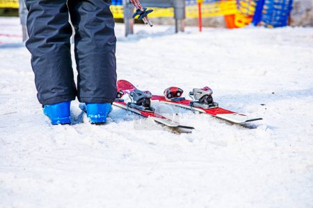 Skifahrer steht morgens in der Nähe des Lifteingangs. Aktiver Familienurlaub