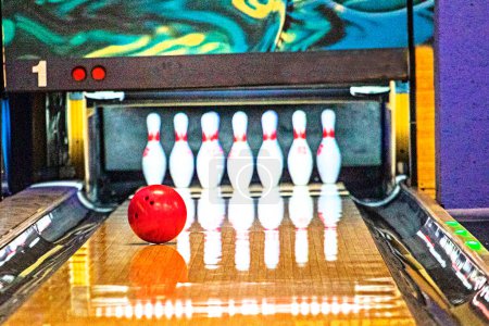 red bowling ball rolls down the lane to knock down pins. Bowling game