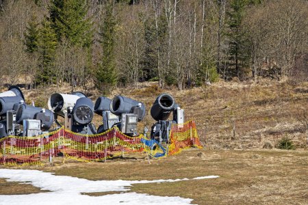 Photo for Non-working snow generator on a slope without snow gear at a resort on a sunny day. Active recreation - Royalty Free Image