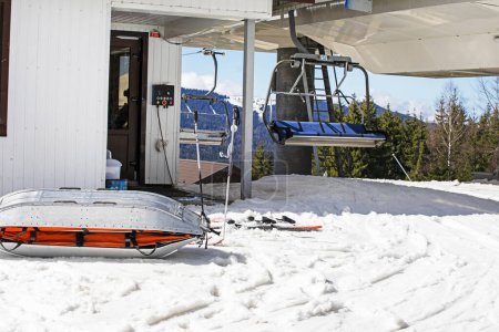 Rettungsschlitten für verletzte Skifahrer in der Nähe der Skipiste an einem sonnigen Tag. Aktiv- und Erholungsurlaub