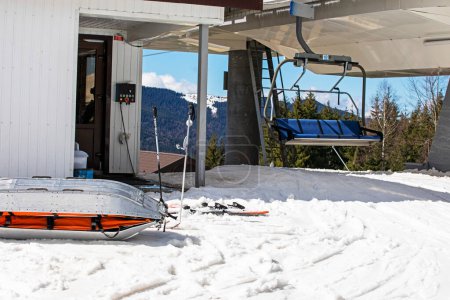Rettungsschlitten für verletzte Skifahrer in der Nähe der Skipiste an einem sonnigen Tag. Aktiv- und Erholungsurlaub
