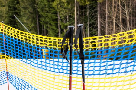 ski poles near the protective net on the ski slope. safety and active recreation