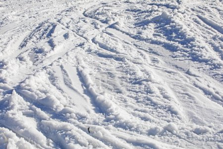 fond abstrait de neige blanche avec des traces de skieurs par une journée ensoleillée