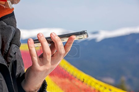 skier is talking on the phone on a snowy slope at a ski resort. Active recreation and doing business