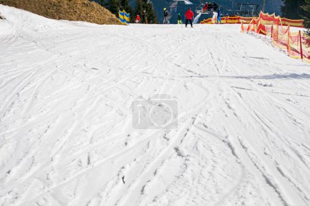 esquiadores en una pista de nieve para principiantes en un día soleado. recreación activa