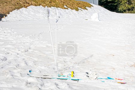 ski poles and skis on a snowy slope on a sunny day