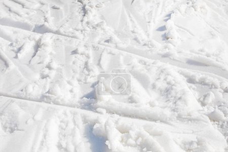 fond abstrait de neige blanche avec des traces de skieurs par une journée ensoleillée