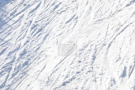 abstract background of white snow with traces of skiers on a sunny day