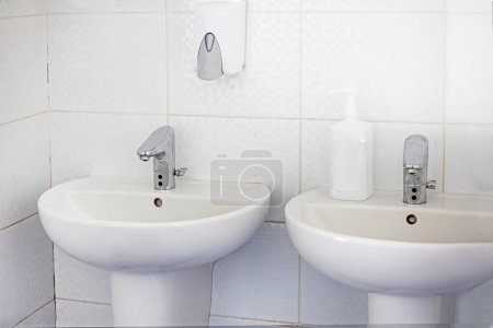 fregaderos y grifos blancos en el baño. diseño moderno