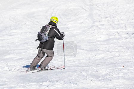 skier descends from a slope on a sunny day. Active recreation. School holidays