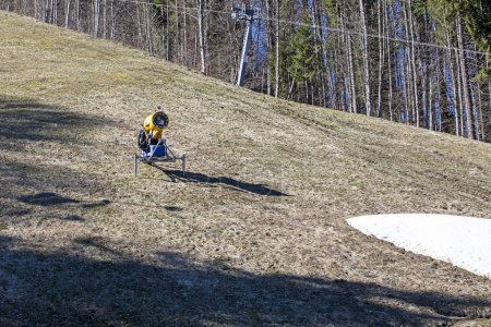 snow generator on a flat slope without snow on a sunny day