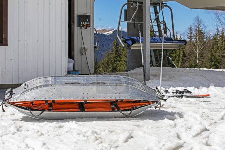 medical sled on a downhill slope for tramping downhill skiers and snowboarders. Active and safe recreation