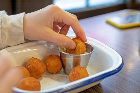 eating cheese balls with garlic sauce in a cafe