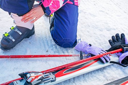 skiers re-strap their boots for a moderately difficult ski slope. Leisure