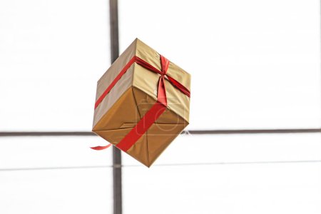 gift wrapped in a box with a red ribbon. holiday