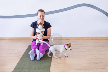 glückliches Mädchen beim Yoga mit kleinen Jack Russell Terrier Welpen. Gesunder Lebensstil und Meditation