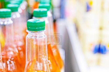 orange drinks in plastic containers on the counter in a supermarket