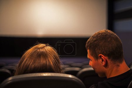 loving couple sits in the cinema hall in front of the reception. family vacation