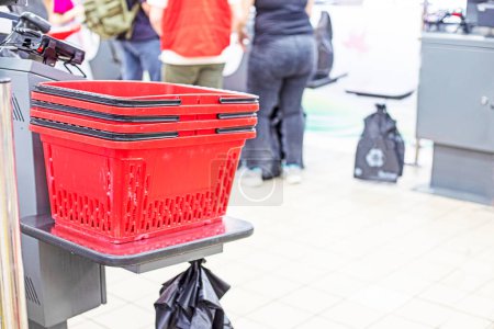 Las cestas de plástico para comprar alimentos en un supermercado están en la caja de autoservicio. Nuevas tecnologías
