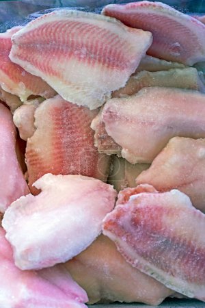 raw pieces of frozen fish fillet on the counter in a store. Top view, diet