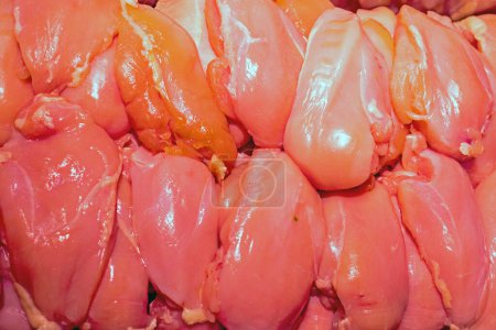 raw pieces of chopped chicken fillet on the counter in a store. Top view, diet