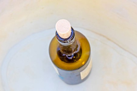 open bottle of chilled white wine on a light background
