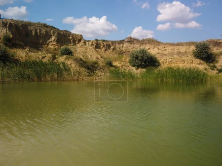 Photo for Water Reservoir lies at the convergence of the valleys of the Greenfield and Chew Brooks above the village of Ukraine. Rural lake with reed High quality photo - Royalty Free Image
