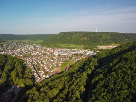 Blick aus der Vogelperspektive auf ein buntes Dorf mitten in den Bergen in der deutschen Provinz. Die Landschaft besteht aus grünen Bergen und grünen Wiesen. Hochwertiges Foto