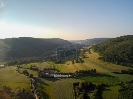 Aerial view on small town - colorful fields and trees in autumn. High quality photo